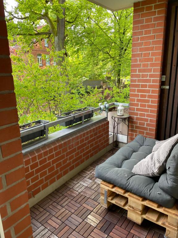 a patio with a couch on a brick wall at 3-Zimmer Nähe Messe & Maschsee in Hannover
