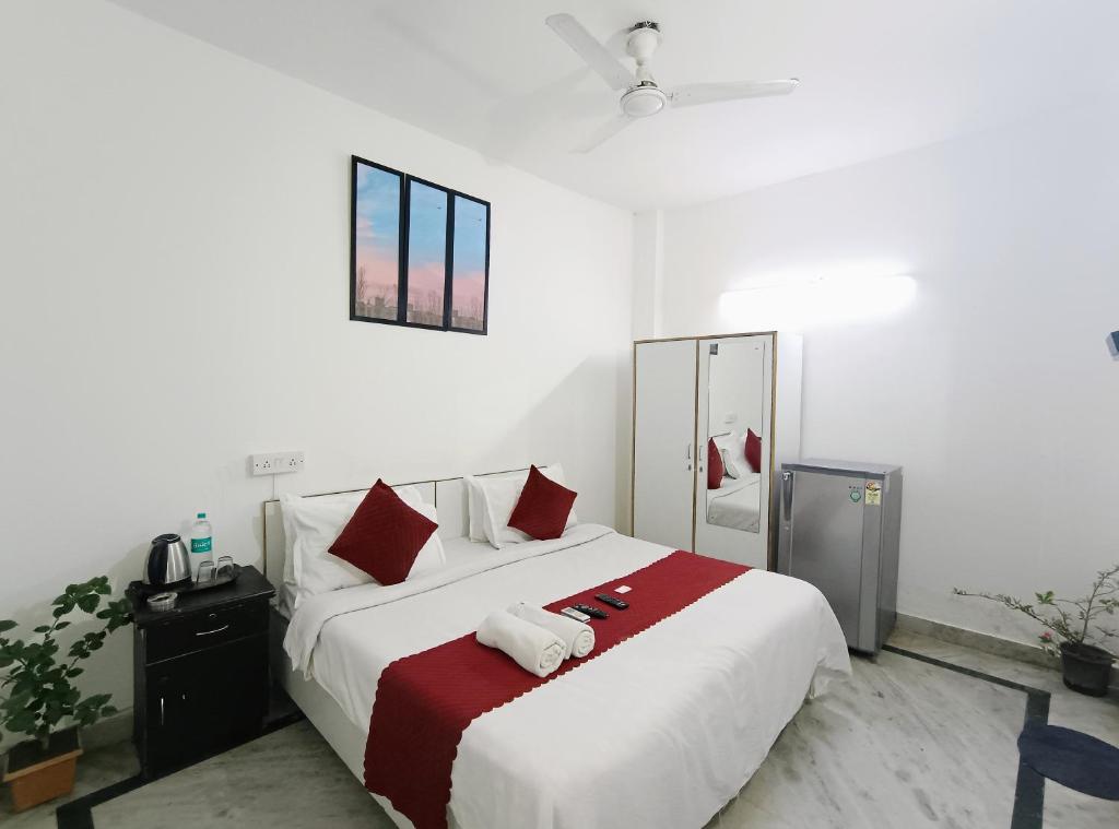 1 dormitorio con 1 cama blanca grande con almohadas rojas en Hotel Hauz Khas Fort View en Nueva Delhi