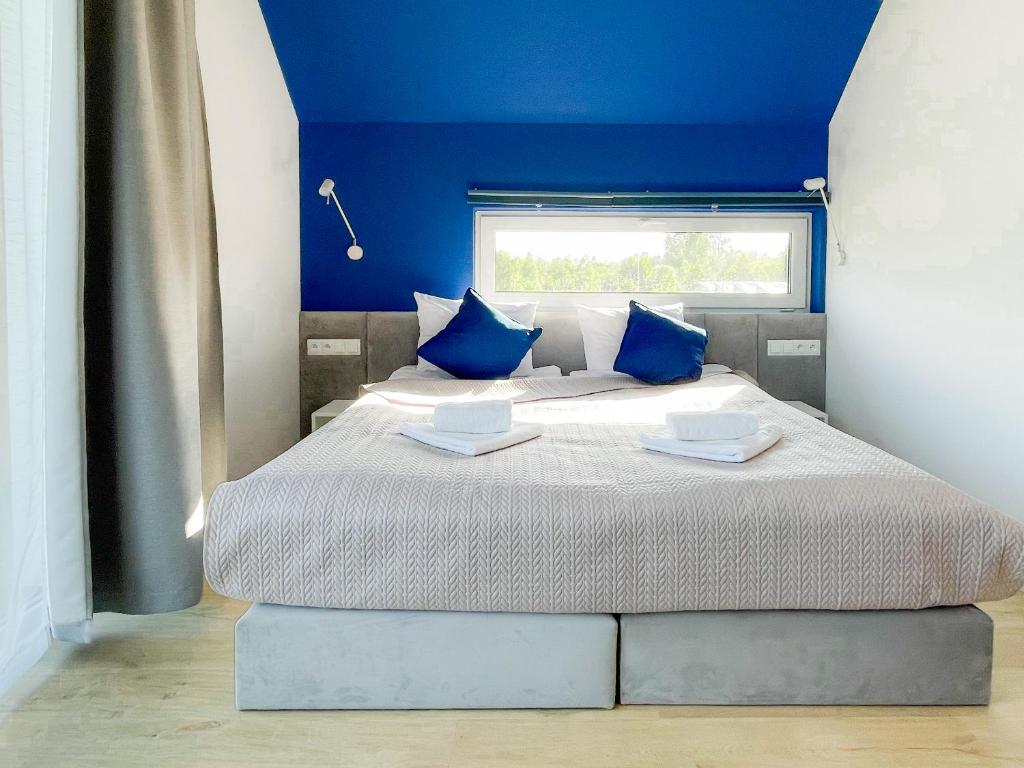 ein Schlafzimmer mit einem großen Bett mit blauen Wänden in der Unterkunft Między Wodami in Międzywodzie