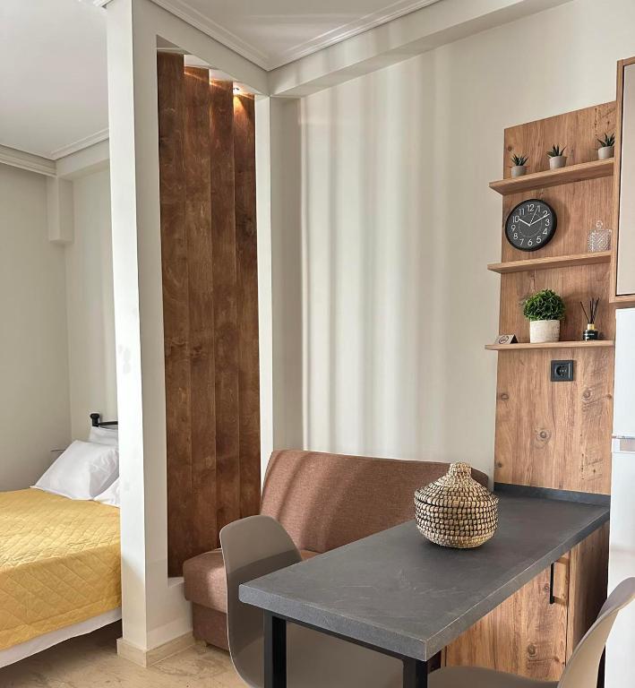 a room with a table and a bed and a clock at Cozy Karystos Apartment in Karistos