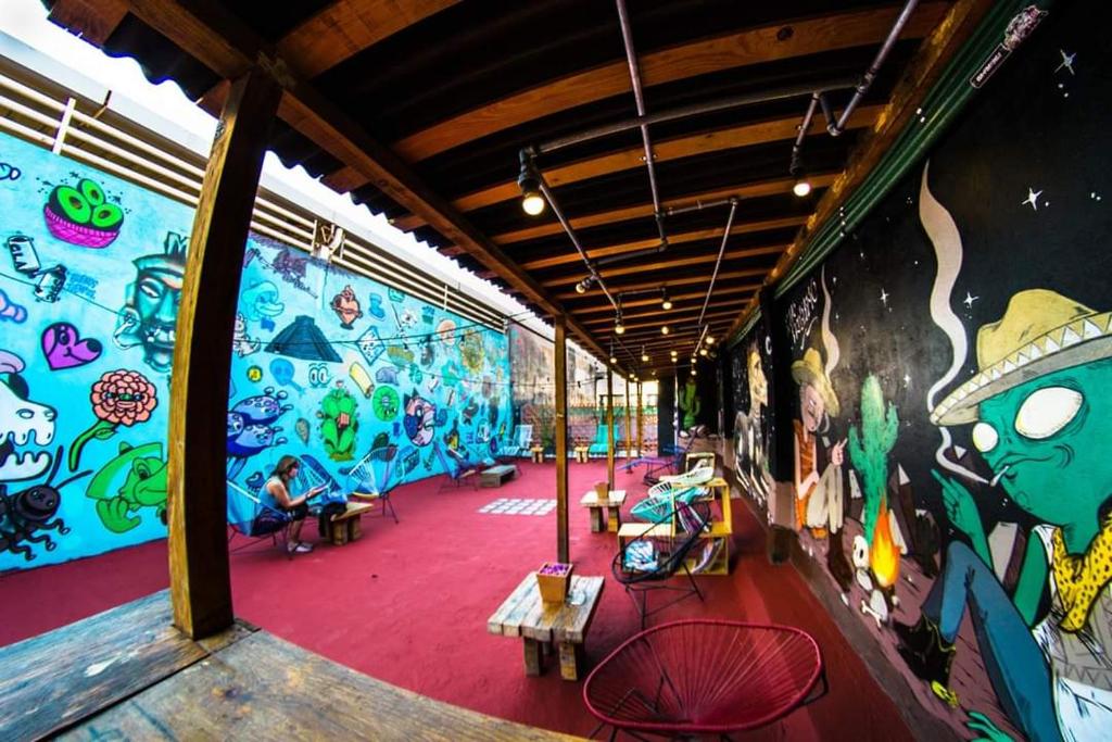 a room with a wall covered in colorful graffiti at Gente de Más Hostel in Puebla