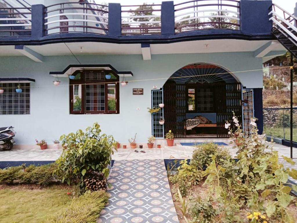 uma casa com uma varanda e um pátio em SOMESH Holiday Home em Uttarkāshi