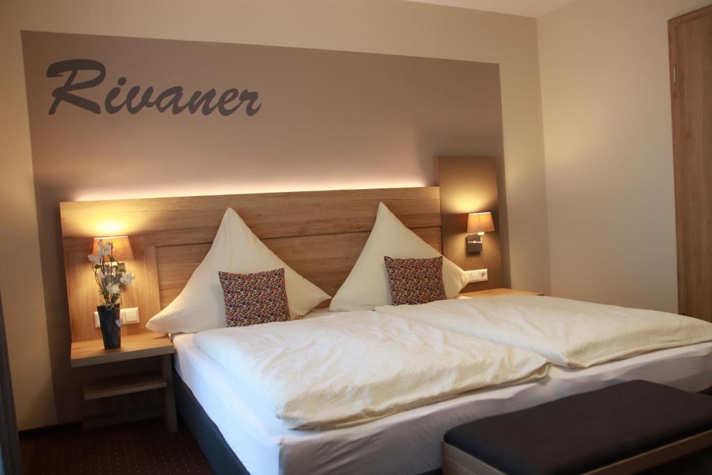 a bedroom with a white bed with a sign on the wall at Weinhaus Gräfen in Cochem