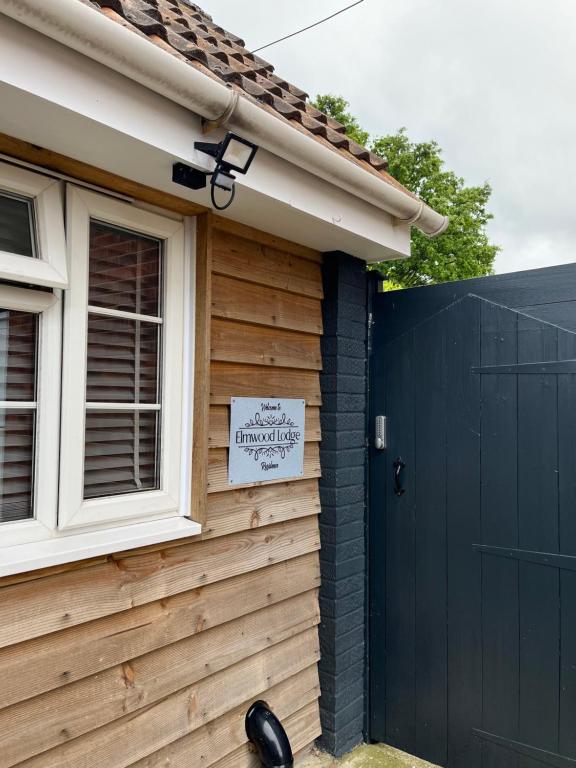 une maison avec un panneau sur son côté dans l'établissement Elmwood Lodge, à Kent