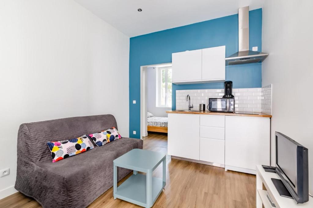 un salon avec un canapé et une cuisine dans l'établissement Studio proche Plage du Mourillon Confort et Charme, à Toulon