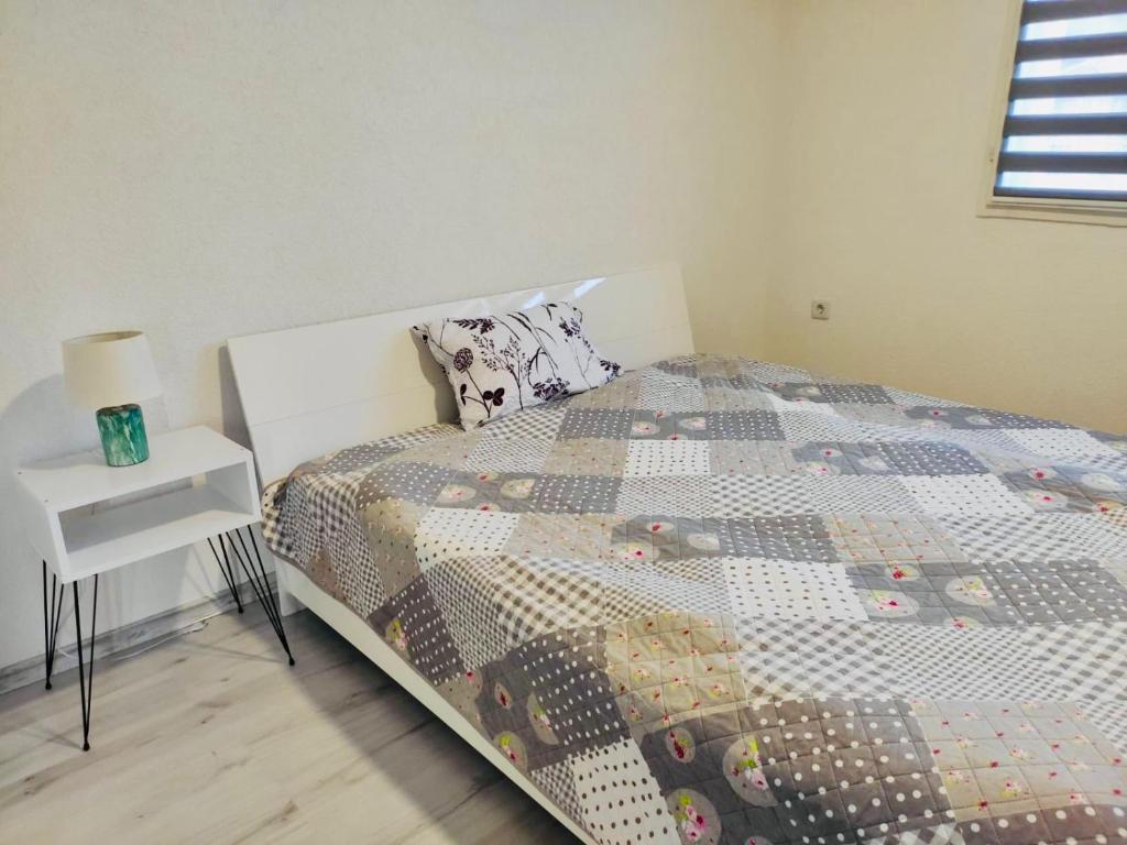 um quarto com uma cama com uma colcha em Apartman Mir em Visoko
