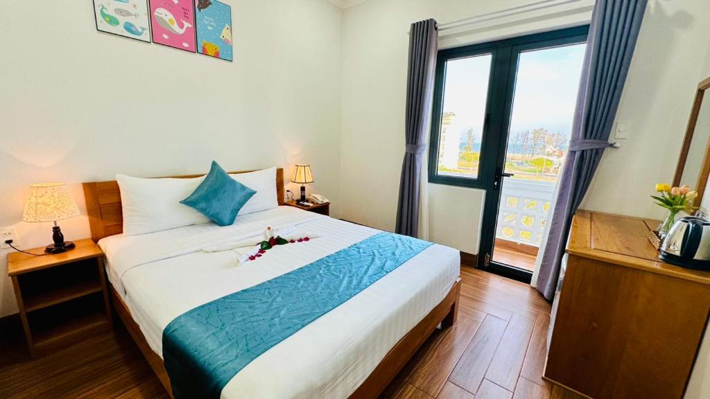 um quarto com uma cama grande e uma janela grande em Hotel Phạm Gia Phan Thiết em Phan Thiet