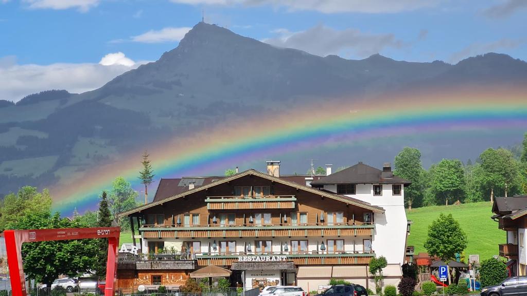 un arco iris sobre un hotel con una montaña en el fondo en Sport und Familienhotel Klausen, en Kirchberg in Tirol