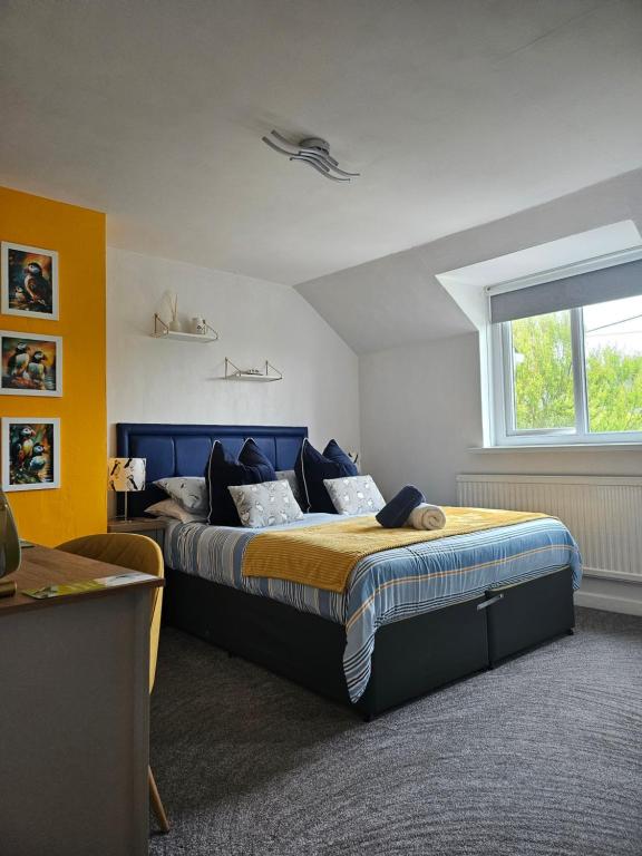 a bedroom with a large bed with a blue headboard at Four Winds B&B StDavids in St. Davids