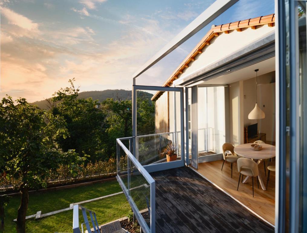 a house with a balcony with a dining table at O Souto da Aldea Ribeira Sacra Parada de Sil in Parada del Sil
