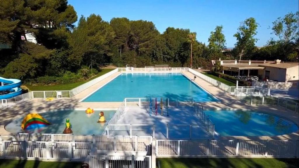 une grande piscine bleue avec toboggan dans l'établissement Bel appartement rénové 4 personnes proche plage et toutes commodités, à Six-Fours-les-Plages