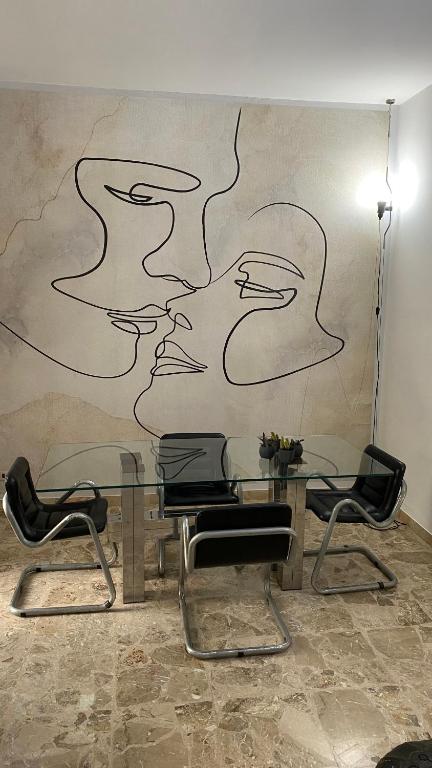 a table with chairs and a painting on a wall at La casa al mare in Grottammare