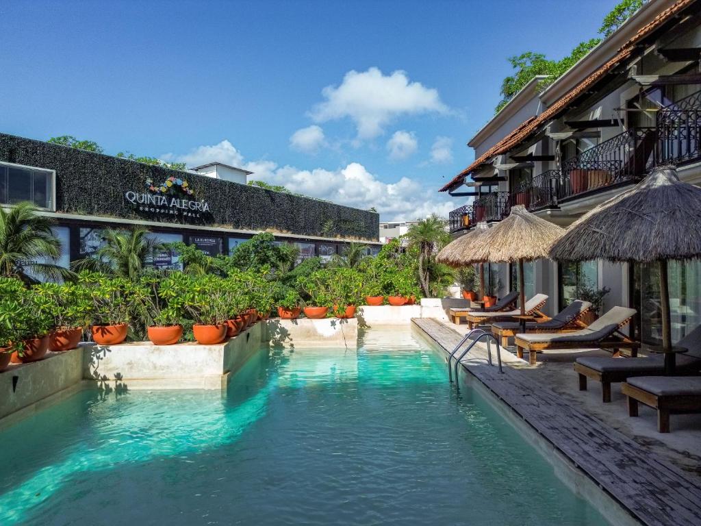 a swimming pool in the middle of a resort at Caribbean Paradise Hotel Boutique & Spa by Paradise Hotels - 5th Av Playa del Carmen in Playa del Carmen