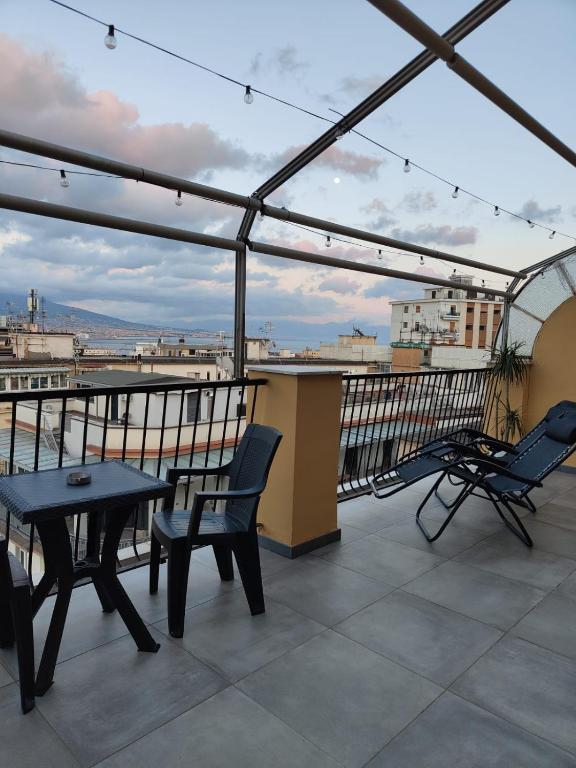 a patio with a table and chairs on a roof at Cuore Napoli Centro in Naples
