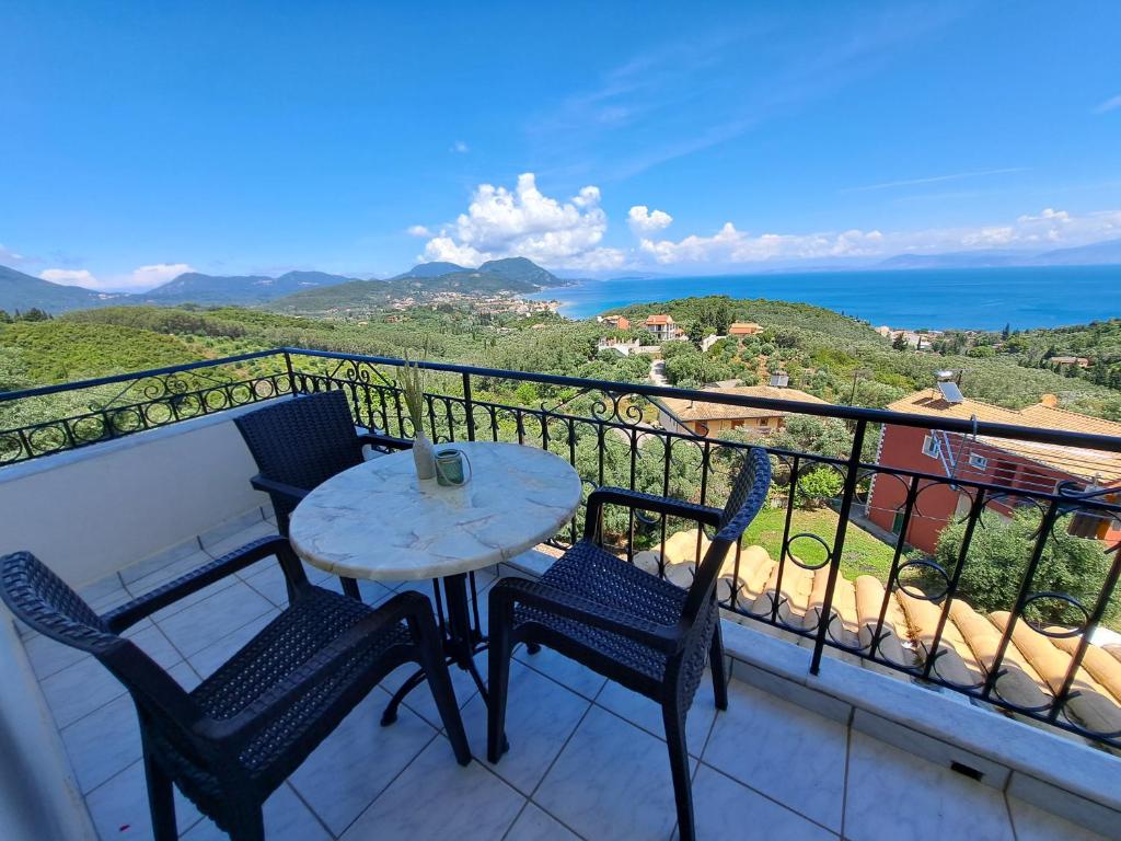 una mesa y sillas en un balcón con vistas al océano en 75 Steps Apartments, en Mesongi
