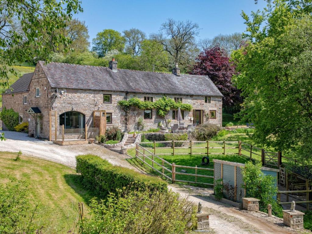 an old stone barn with a garden in front of it at 1 Bed in Waterfall 89733 in Waterhouses