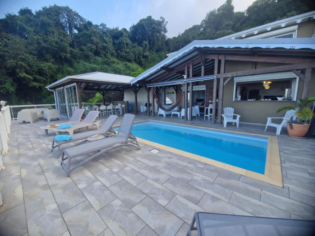 een patio met stoelen en een zwembad bij Villa Lidoam vue mer imprenable in Le Vauclin