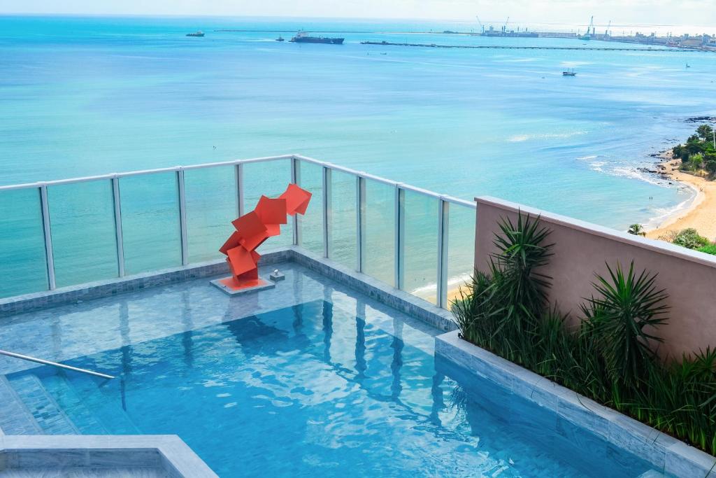 a swimming pool with a view of the ocean at Seara Praia Hotel in Fortaleza