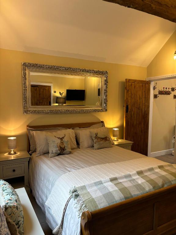a bedroom with a large bed with a mirror at Mulberry House Farm Mulberry Lodge in Chippenham