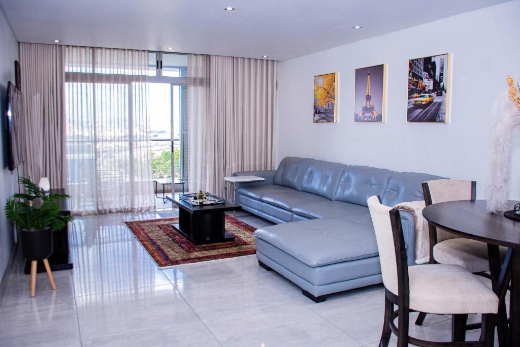 uma sala de estar com um sofá azul e uma mesa em Zeno stay - No Loadshedding em Cidade do Cabo