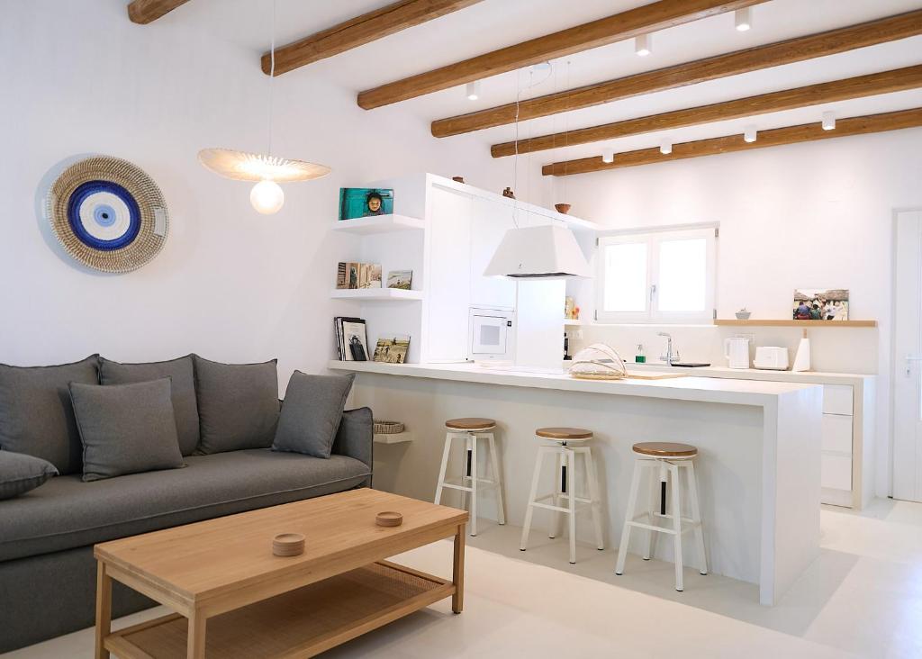 a living room with a couch and a kitchen at Senza's Cycladic Home in Marpissa , Paros in Kampos Paros