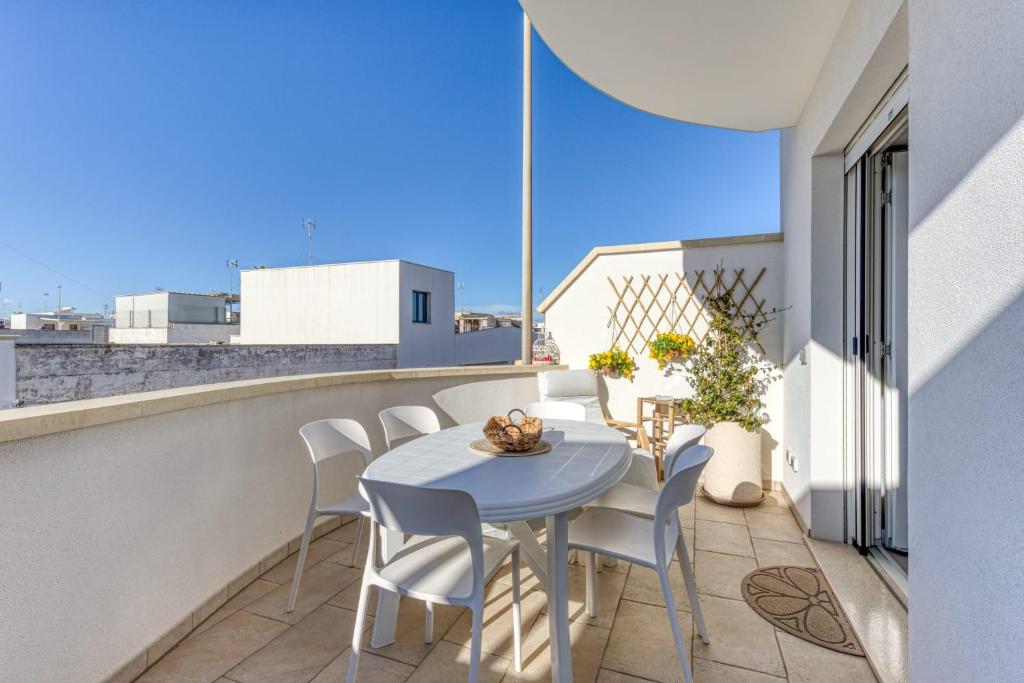 a small balcony with a blue table and chairs at Casa Dandari in Torre San Giovanni Ugento