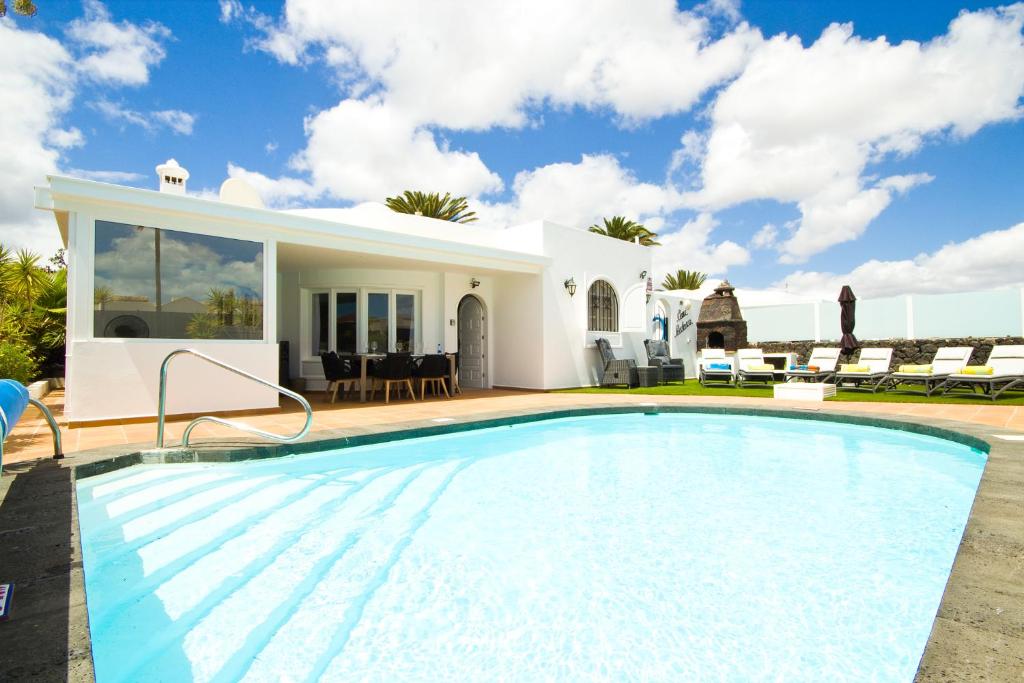 a swimming pool in front of a villa at Casa Federico in Puerto del Carmen