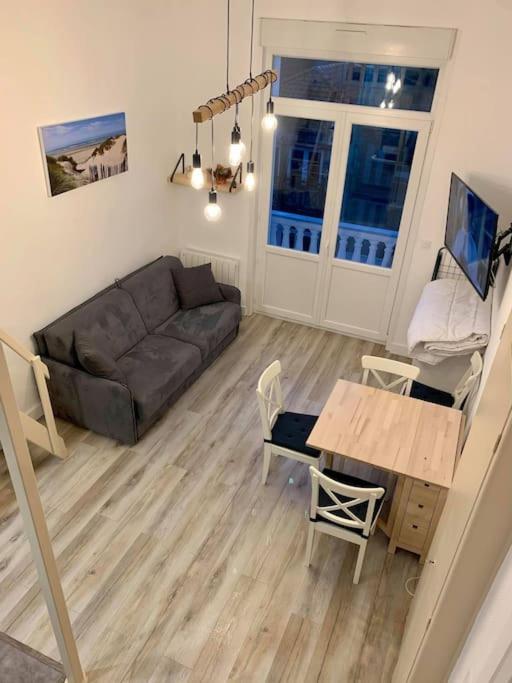 un salon avec un canapé et une table dans l'établissement Studio cosy 2 pers en plein centre avec balcon, à Le Touquet-Paris-Plage