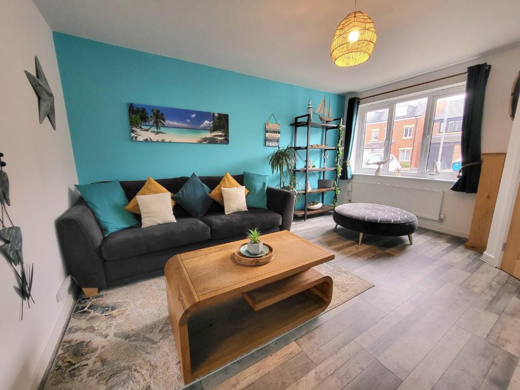 una sala de estar con un sofá y una mesa en Seaside beach themed home with garden and driveway, en Lytham St Annes