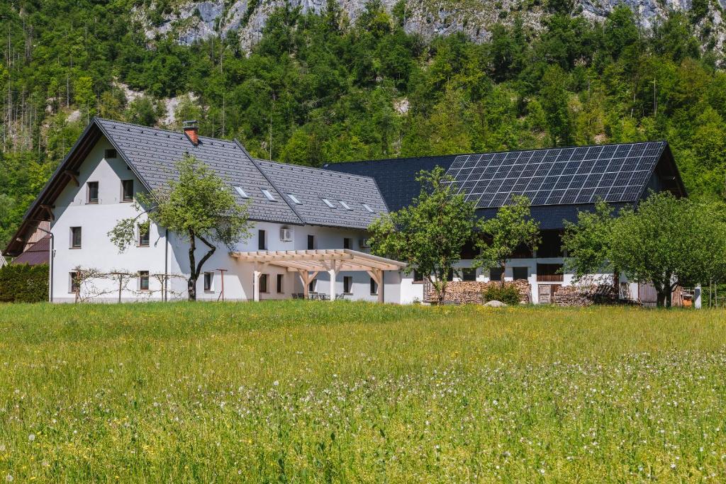 ein Haus mit Sonnenkollektoren auf dem Dach in der Unterkunft Domačija Log v Bohinju in Bohinjska Bistrica