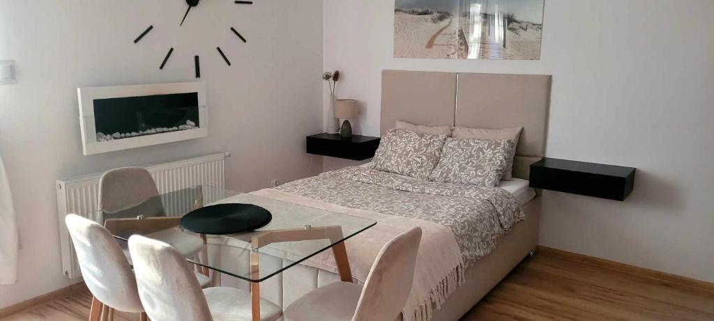 een slaapkamer met een bed en een tafel en stoelen bij Apartament MIODOWY przy plaży in Krynica Morska