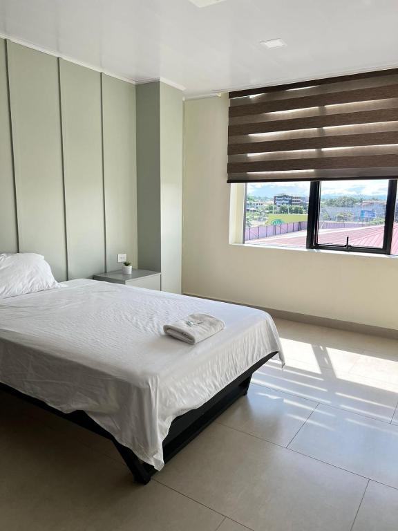 Un dormitorio con una cama grande y una ventana en Hotel Amazonas Suite , habitación sencilla en Nueva Loja