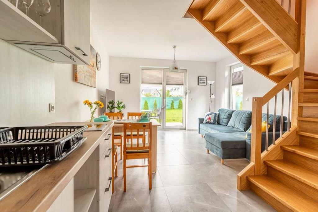 una cocina con una escalera que conduce a una sala de estar. en Domki Adek 2, en Władysławowo