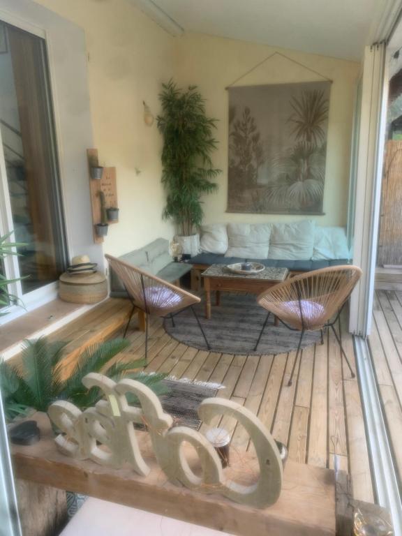 - un salon avec un canapé et des chaises sur une terrasse couverte dans l'établissement La baie d’Alon, à Saint-Cyr-sur-Mer