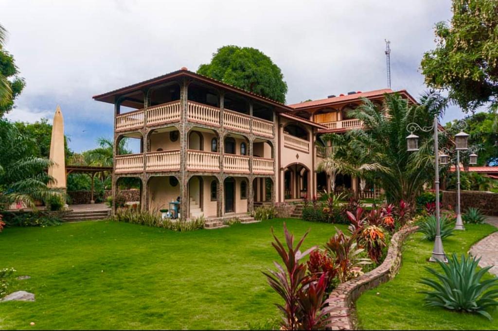 une grande maison avec une cour verdoyante dans l'établissement Hotel El Reith Lake, à Granada