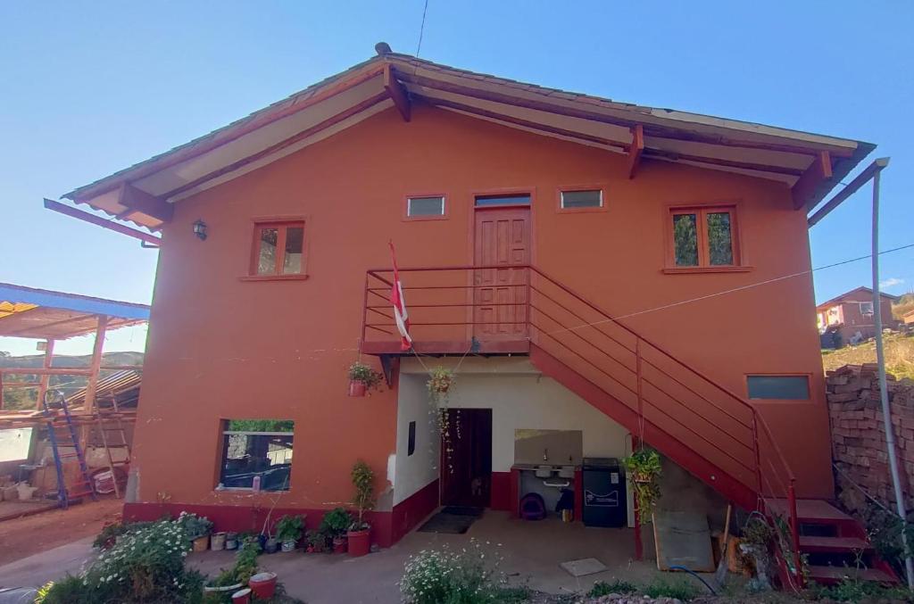 Una casa roja con una escalera en ella. en Kapaq Country House, en Cusco