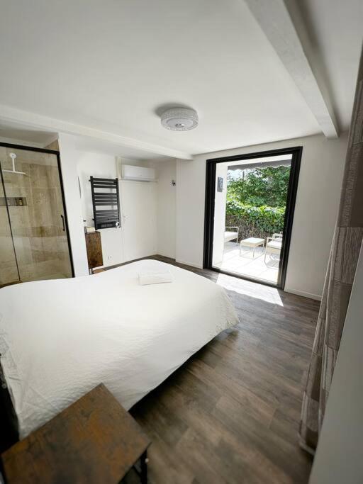 une chambre avec un grand lit blanc et une fenêtre dans l'établissement La Dolce Casa - centre Lamanon, à Lamanon