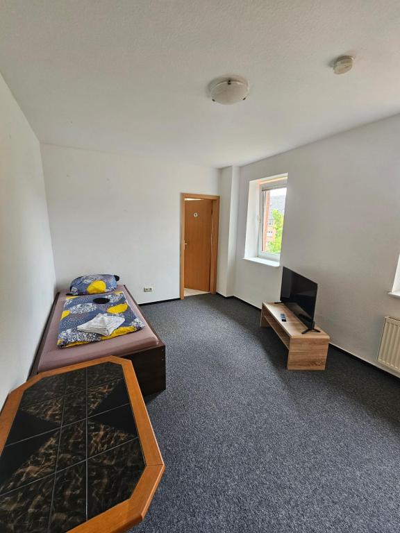 1 dormitorio con 1 cama y TV. en Einfache Ubernachtung mit eigenem Bad en Rostock