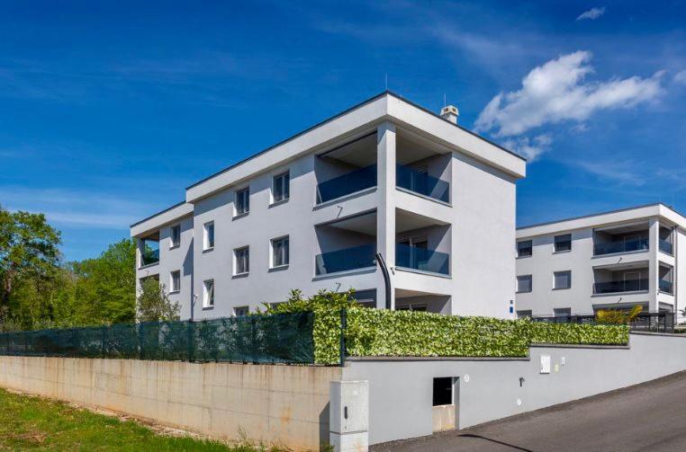 a white building with ivy on the side of it at Apartman Anavi in Sveti Vid-Miholjice