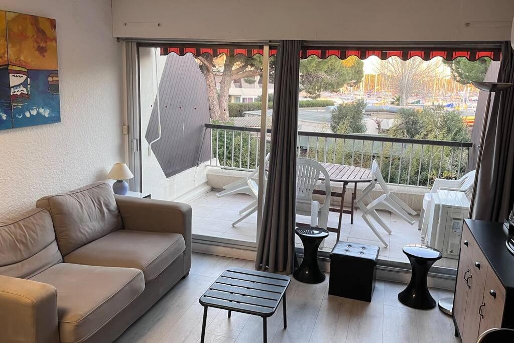 d'un salon avec un canapé et un balcon. dans l'établissement Beau studio climatisé 4 personnes, au Grau-du-Roi