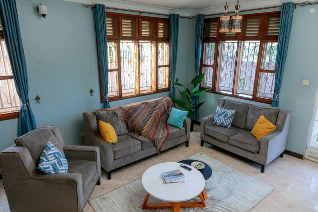 uma sala de estar com dois sofás e uma mesa em The Mbuya Residence em Kampala