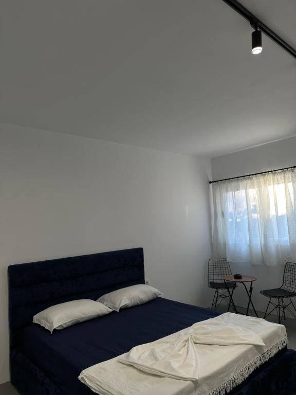 a bedroom with a blue bed and a window at Sunny Rentals in Vlorë