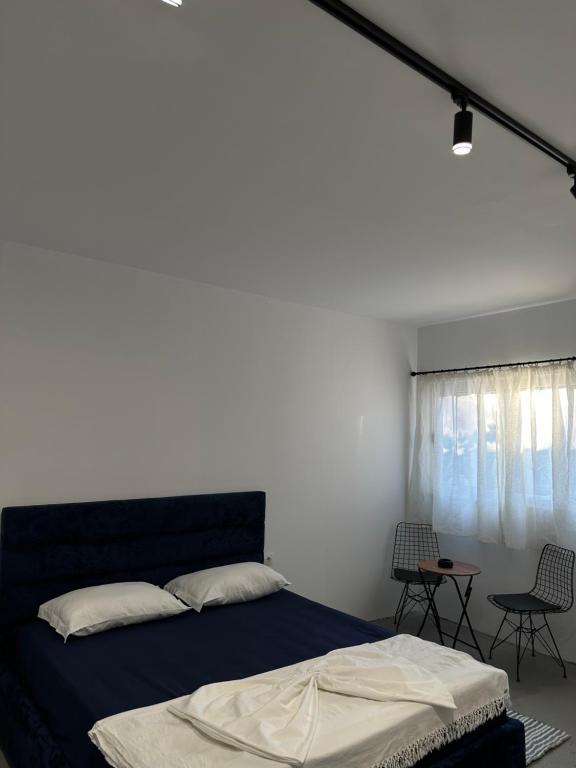 a bedroom with a bed and a table and chairs at Sunny Rentals in Vlorë