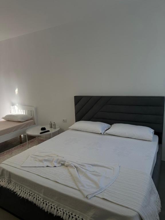 a bedroom with a large bed with white sheets at Sunny Rentals in Vlorë