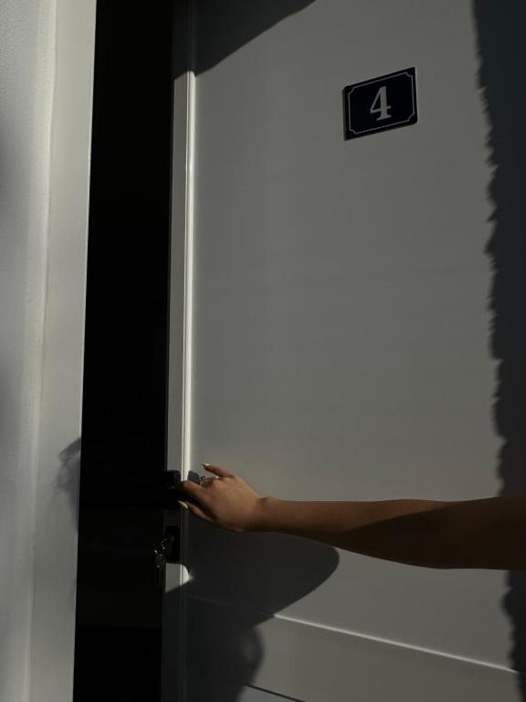 a person opening a door with their hand on it at Sunny Rentals in Vlorë