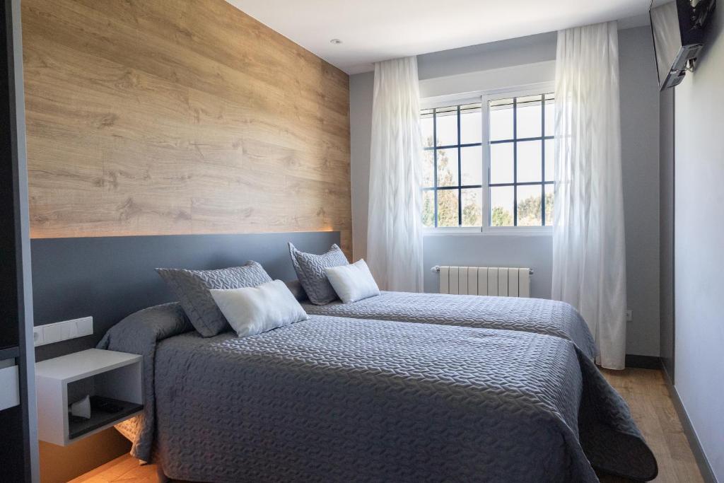 Кровать или кровати в номере Hostal O'Cruceiro