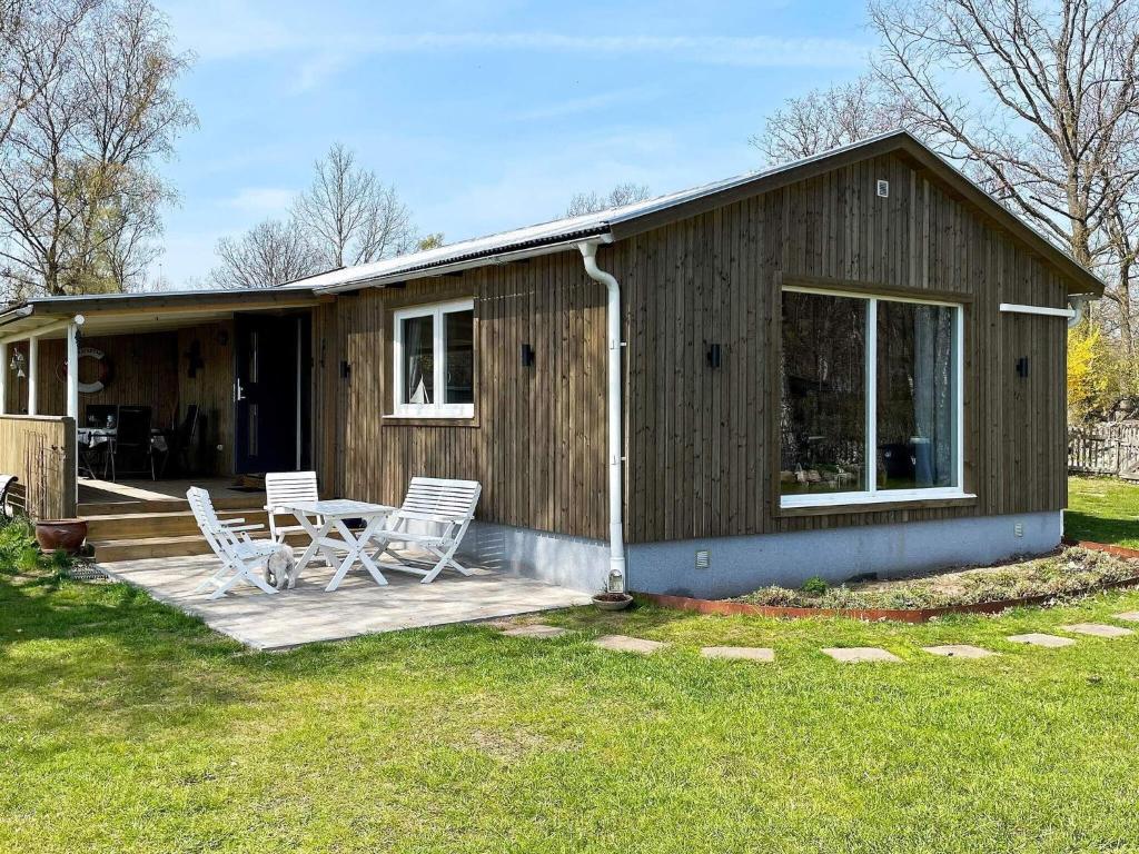 ein Haus mit zwei Stühlen und einem Tisch auf einer Terrasse in der Unterkunft 5 person holiday home in S DER KRA in Söderåkra