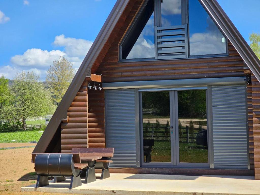 a house with sliding glass doors and a bench at Kucica Hrasno in Breza