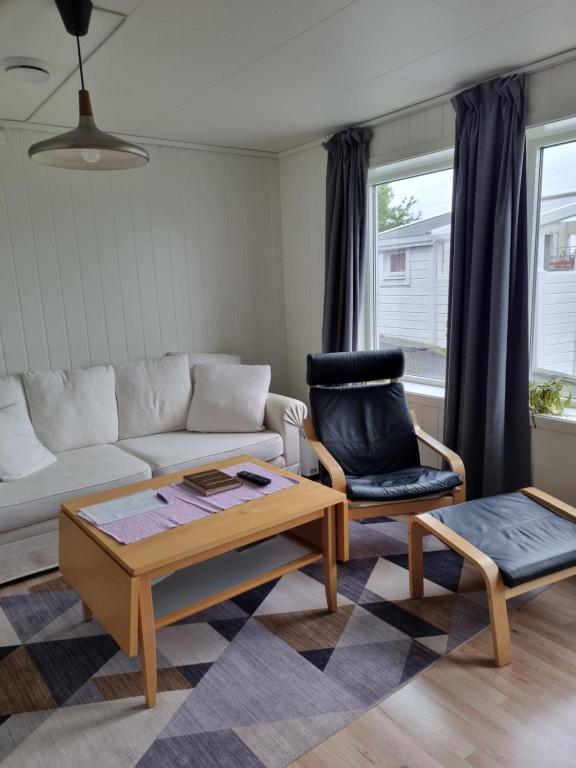 een woonkamer met een bank en een stoel bij Not far from famous Pulpit Rock and Stavanger in Strand