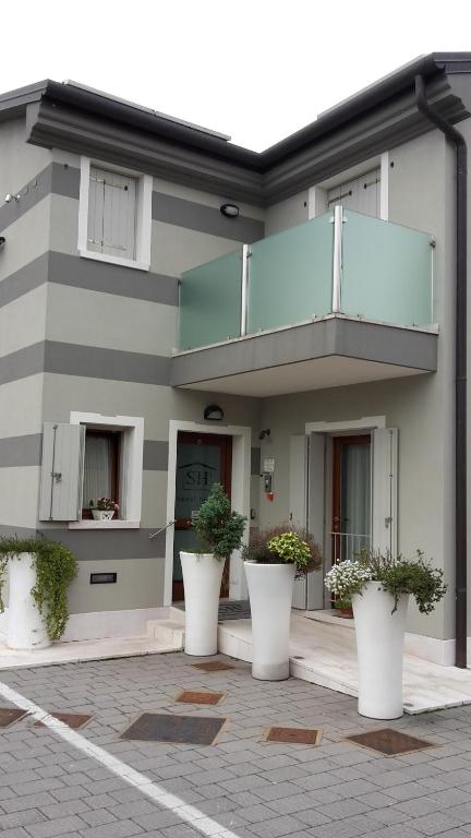 a building with white pots of plants in front of it at Sweet Home in Treviso